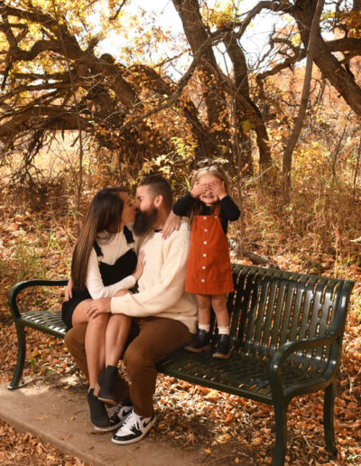 parents kissing with little girl hiding her eyes